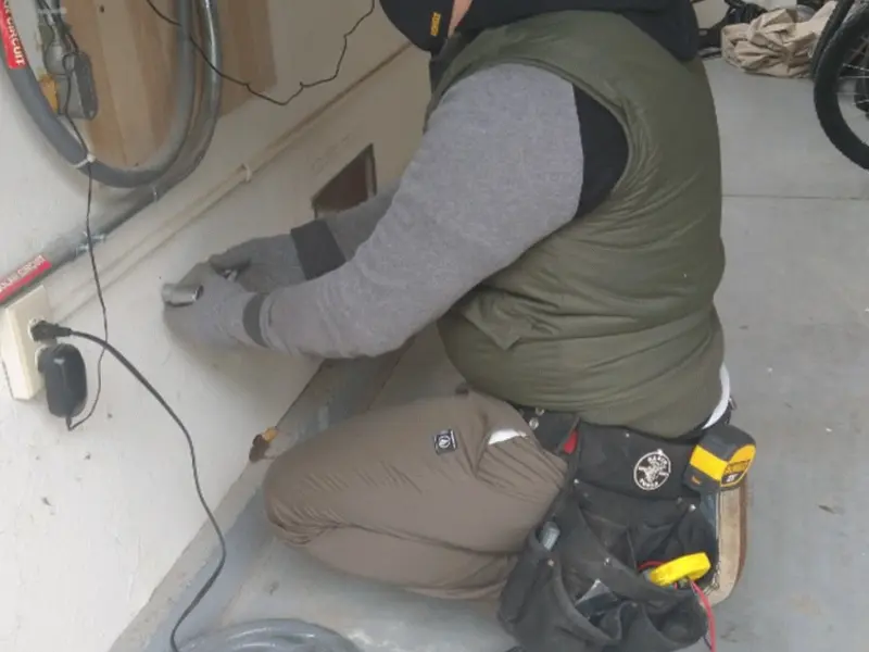 Electrician performing outlet wiring in a Aurora garage